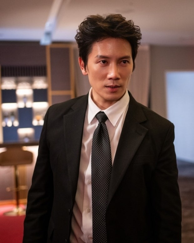 Actor Ji Sung portraying former gang boss Park Hae-gang in the K-drama The Apartment Job, flashing a sharp, intense, and chilling gaze that captures his rugged charisma